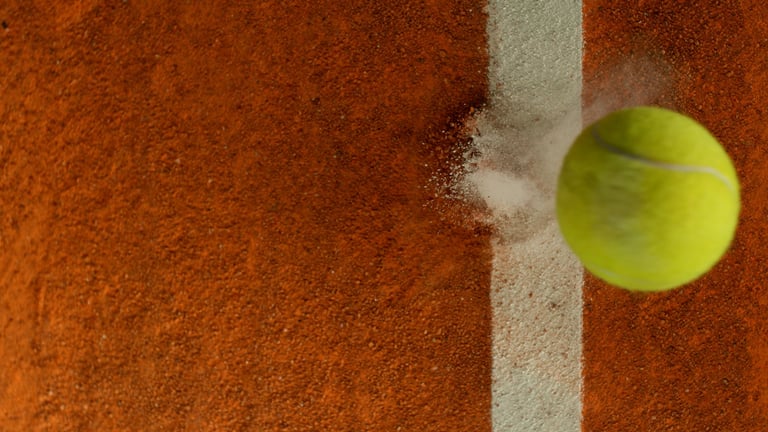 Tennis ball hitting clay court